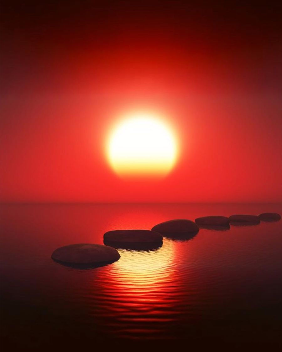 Rote Sonne über ruhigem Wasser, Trittsteine führen zum Horizont